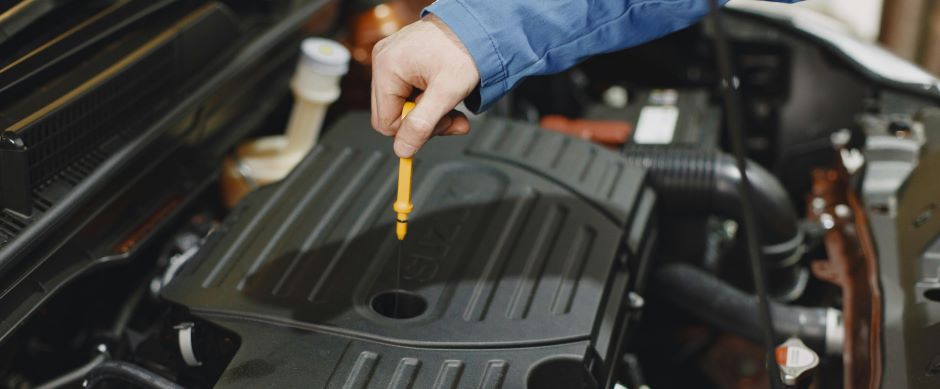 Person Checking the Oil of an Engine